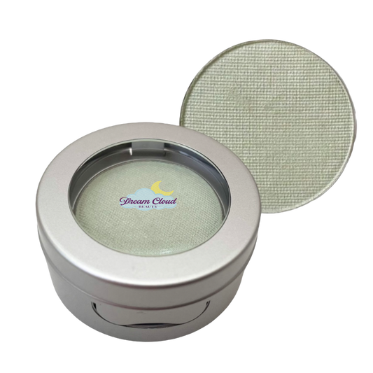 Makeup compact with green eyeshadow and 'Dream Cloud' branding on a white background